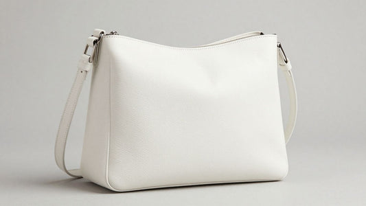 White leather crossbody bag on a neutral background.